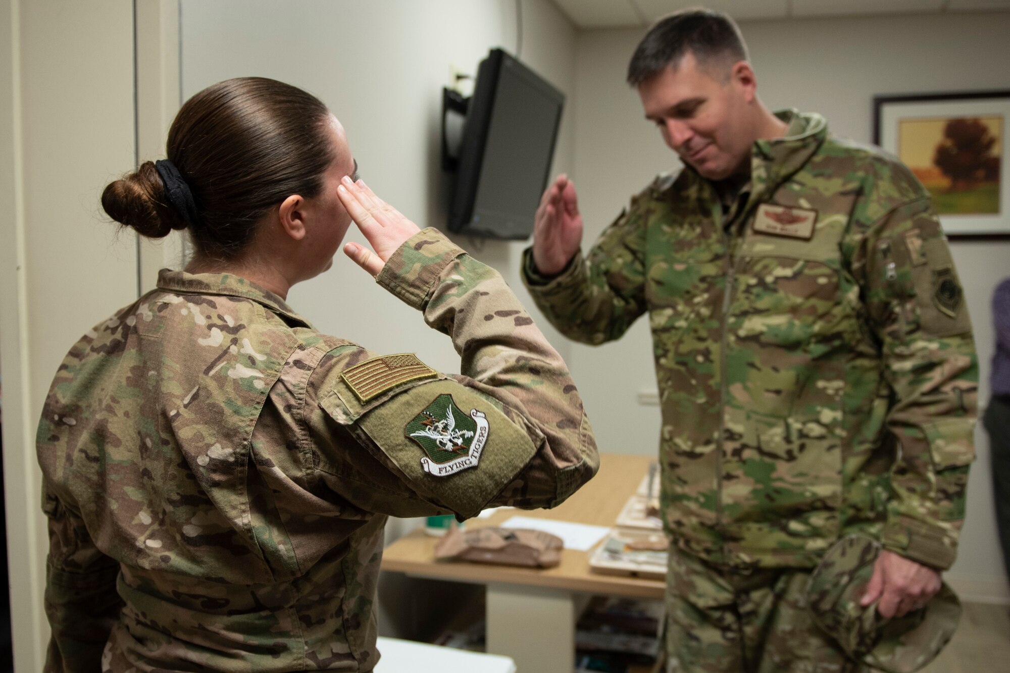 A photo of an Airman saluting leadership after getting coined.