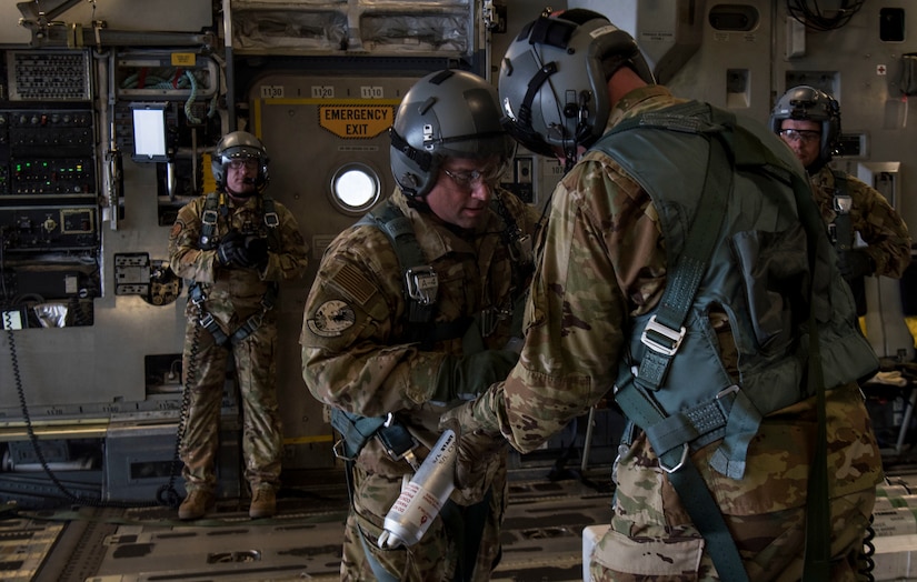 Chief Master Sgt. Donald Rouse, a loadmaster with the 39th Rescue Squadron, instructs a test participant on properly handling procedures of a position marker onboard a C-17 Globemaster III from Joint Base Charleston during Air Mobility Command Test and Evaluation Squadron’s assessment of tactics, techniques and procedures for astronaut rescue and recovery efforts Jan. 22, 2020, at Patrick Air Force Base, Fla.