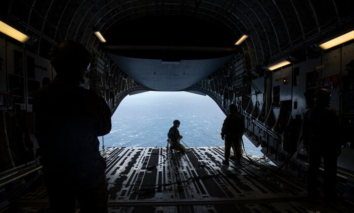 Master Sgt. Cecil Dickerson, a loadmaster with the 144th Airlift Squadron, prepares to deploy illumination flares and position markers from the ramp of a C-17 Globemaster III from Joint Base Charleston during Air Mobility Command Test and Evaluation Squadron’s assessment of tactics, techniques and procedures for astronaut rescue and recovery efforts Jan. 22, 2020, off the coast of Florida near Patrick Air Force Base.