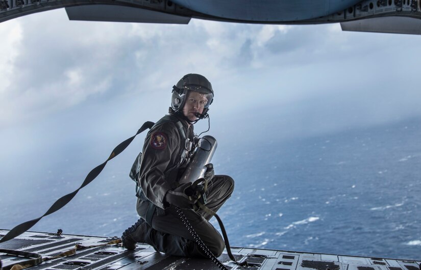 Tech. Sgt. Seth Dunworth, 15th Airlift Squadron loadmaster, prepares to deploy an illumination flare from the ramp of the aircraft during Air Mobility Command Test and Evaluation Squadron’s assessment of tactics, techniques and procedures for astronaut rescue and recovery efforts Jan. 22, 2020, off the coast of Florida near Patrick Air Force Base