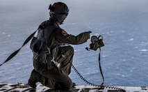 Tech. Sgt. Seth Dunworth, 15th Airlift Squadron loadmaster, deploys an illumination flare from the ramp of the aircraft during Air Mobility Command Test and Evaluation Squadron’s assessment of tactics, techniques and procedures for astronaut rescue and recovery efforts Jan. 22, 2020, off the coast of Florida near Patrick Air Force Base.