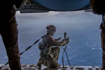 Tech. Sgt. Seth Dunworth, 15th Airlift Squadron loadmaster, deploys an illumination flare from the ramp of the aircraft during Air Mobility Command Test and Evaluation Squadron’s assessment of tactics, techniques and procedures for astronaut rescue and recovery efforts Jan. 22, 2020, off the coast of Florida near Patrick Air Force Base.  (U.S. Air Force photo by Staff Sgt. Tenley Long)