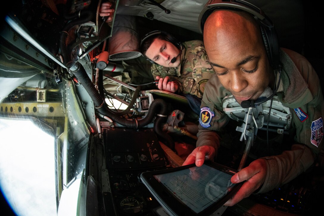Master Sgt. Mark Smith, front, and Senior Airman Corey Marion, 351st Air Refueling Squadron boom operators review a checklist prior to a flight supporting exercise Point Blank at RAF Mildenhall, England, Jan. 30, 2020. The exercise is a recurring large-force exercise designed and co-hosted by the Royal Air Force and the 48th Fighter Wing. (U.S. Air Force photo by Tech. Sgt. Emerson Nuñez)