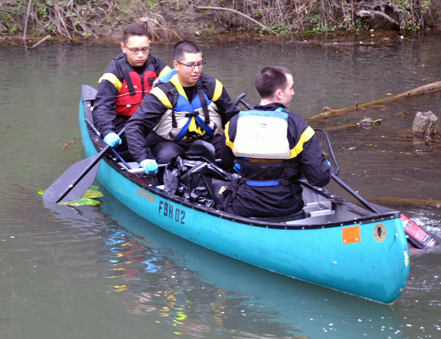 A trio of Soldiers show their prowess on the water as they search the shores of Salado Creek for trash during the annual Basura Bash at Joint Base San Antonio-Fort Sam Houston Feb. 17, 2018.