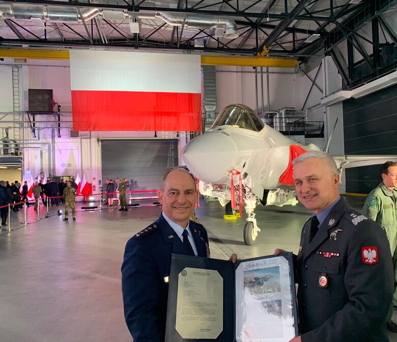Gen. Jeff Harrigian, U.S. Air Forces in Europe and Air Forces Africa commander, presents Inspector of the Polish Air Force, Maj Gen Jacek Pszczola, an official invitation to the European F-35 Users Group, in Dęblin, Poland, Jan. 31, 2020. The users group is a formal and persistent venue where members share information, lessons learned and best practices as the F-35 aircraft are acquired and fielded. (U.S. Air Force photo by 1st Lt. Madeline Krpan)