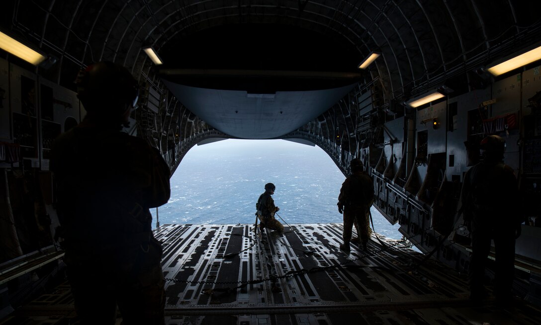 Master Sgt. Cecil Dickerson, a loadmaster with the 144th Airlift Squadron, prepares to deploy illumination flares and position markers from the ramp of a C-17 Globemaster III from Joint Base Charleston during Air Mobility Command Test and Evaluation Squadron’s assessment of tactics, techniques and procedures for astronaut rescue and recovery efforts Jan. 22, 2020, off the coast of Florida near Patrick Air Force Base.