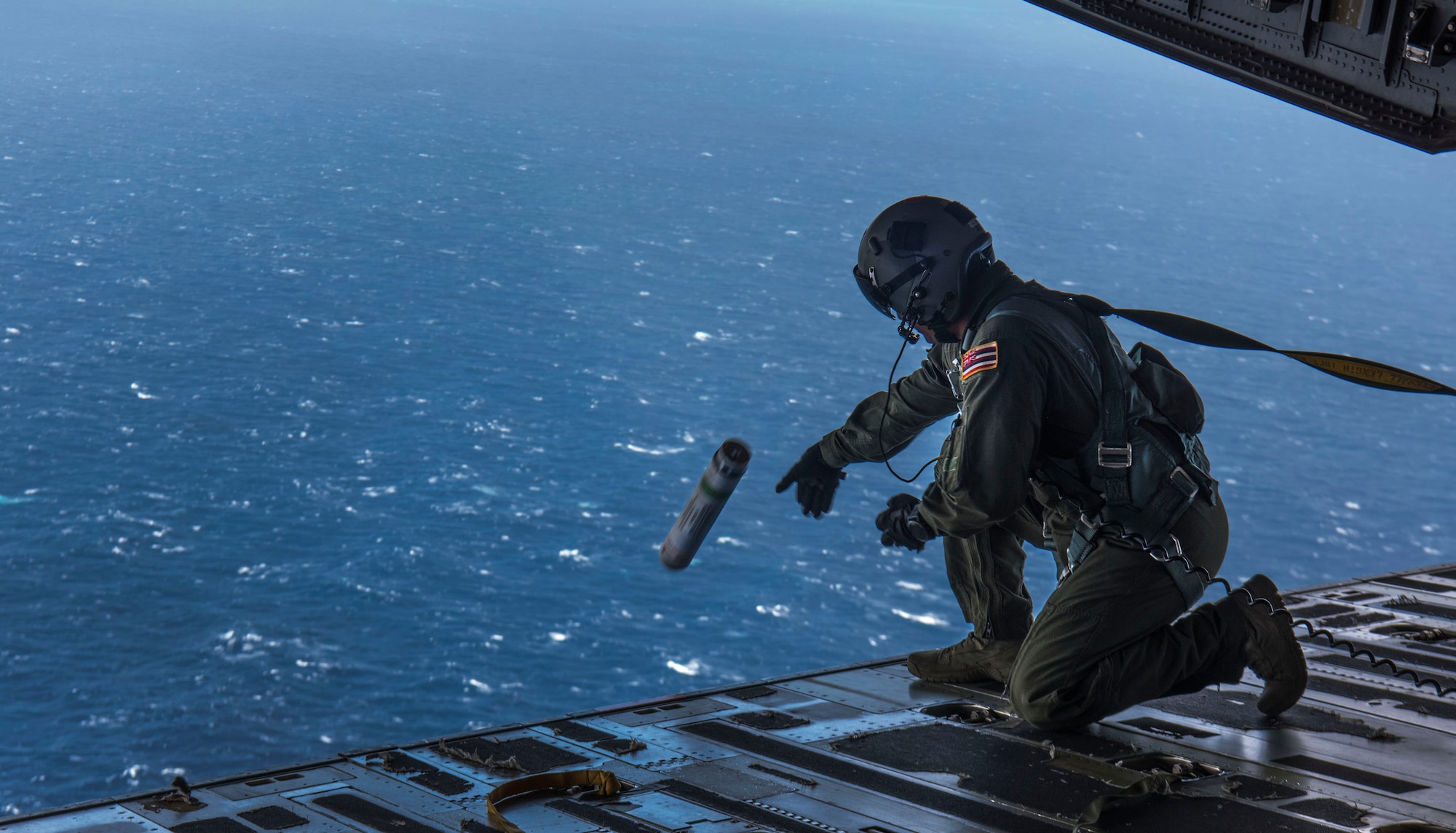 Master Sgt. Randall Yamada, a loadmaster with the 204th Airlift Squadron, deploys a position marker from the ramp of a C-17 Globemaster III from Joint Base Charleston during Air Mobility Command Test and Evaluation Squadron’s assessment of tactics, techniques and procedures for astronaut rescue and recovery efforts Jan. 22, 2020, off the coast of Florida near Patrick Air Force Base.