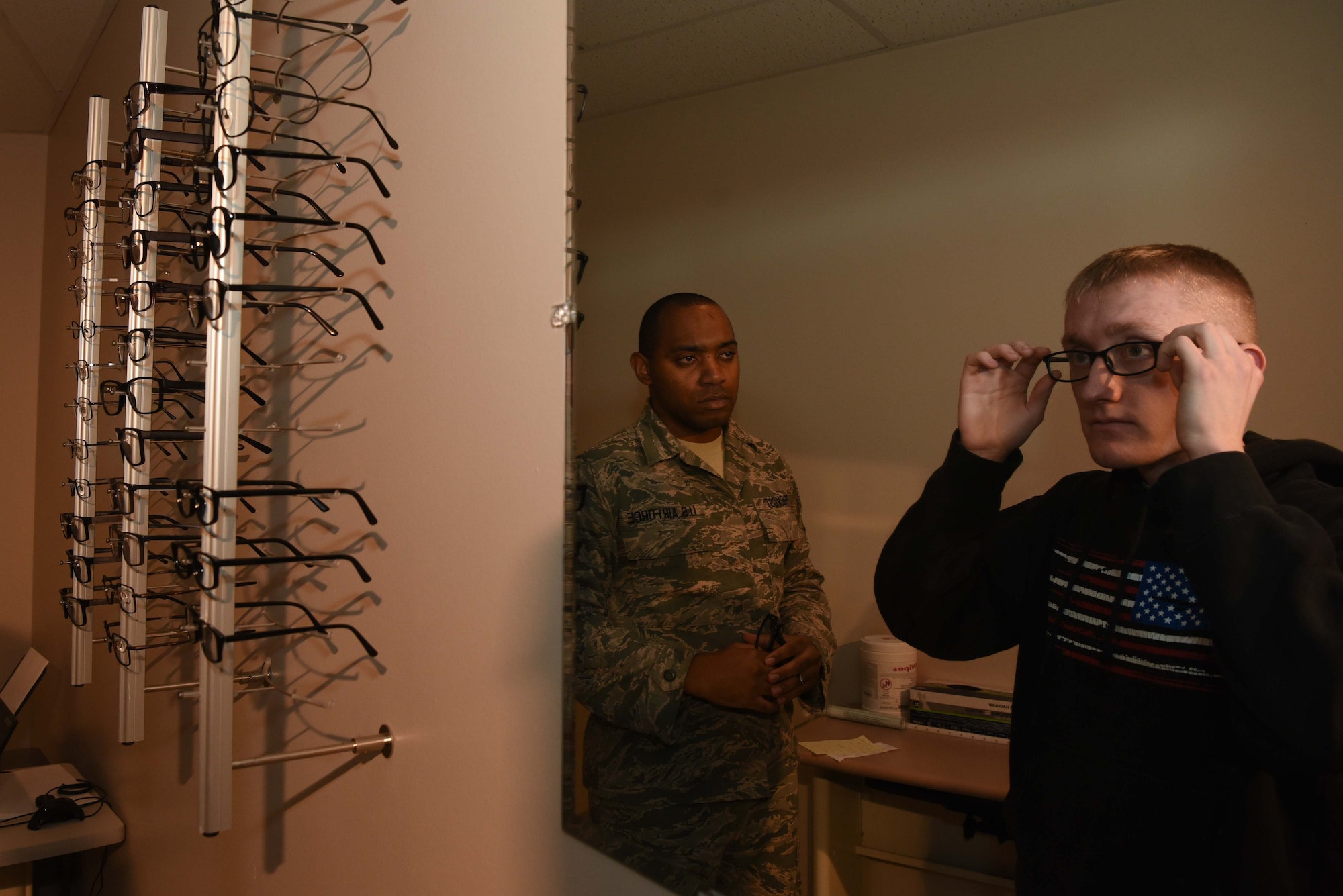 Staff Sgt. Aaron Prevost, 22nd Operational Medical Readiness Squadron NCO-in-charge optometry, helps Senior Airman Mitchel Delfosse, 22nd Aircraft Maintenance Squadron electrical environmental system journeyman, tries on eye glass frames during his eye exam Jan. 30, 2020, at McConnell Air Force Base, Kansas. The optometry clinic provides frames to military personnel and to correct vision so that they can carry on the mission. (U.S. Air Force photo by Airman 1st Class Alexi Bosarge)