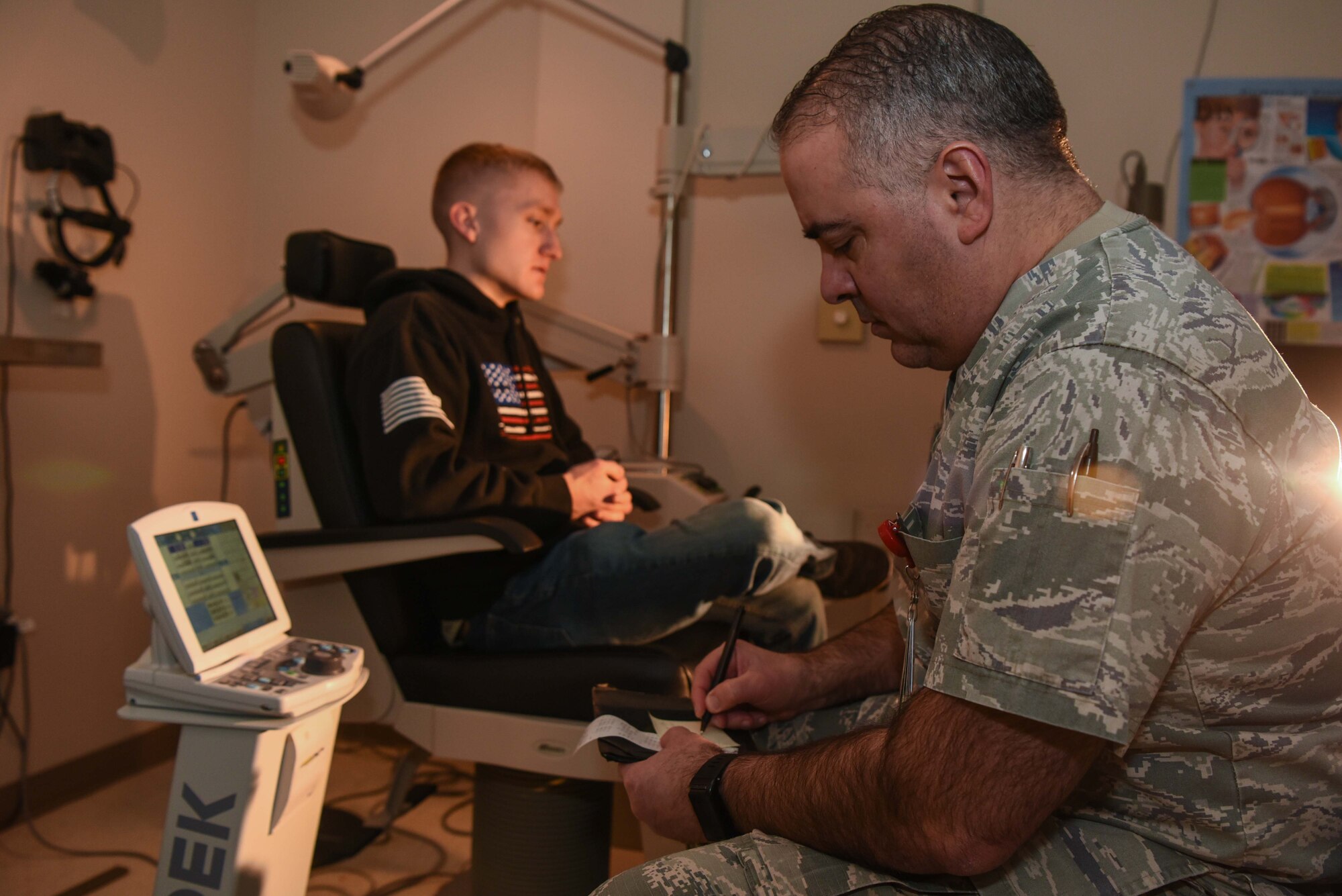 Maj. (Dr.) Gerardo Robles-Morales, 22nd Operational Medical Readiness Squadron optometry flight commander, writes Senior Airman Mitchel Delfosse, 22nd Aircraft Maintenance Squadron electrical environmental system journeyman, a prescription Jan. 30, 2020, at McConnell Air Force Base, Kansas. Robles-Morales explained that all local military dependents are able to be seen by the base optometrist. (U.S. Air Force photo by Airman 1st Class Alexi Bosarge)