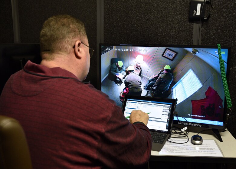 Emergency Medical Responder Course Training Instructor for the 312th Training Squadron, Charles Almeida, monitors students and controls the HAL Manikin, during a mock emergency medical situation from a separate control room Jan. 30, 2020, at the Louis F. Garland Department of Defense Fire Academy on Goodfellow Air Force Base, Texas. The instructors of the EMR course can control the manikins' vitals, speech, and eye movements, including pupil dilation. (U.S. Air Force photo by Airman 1st Class Robyn Hunsinger)