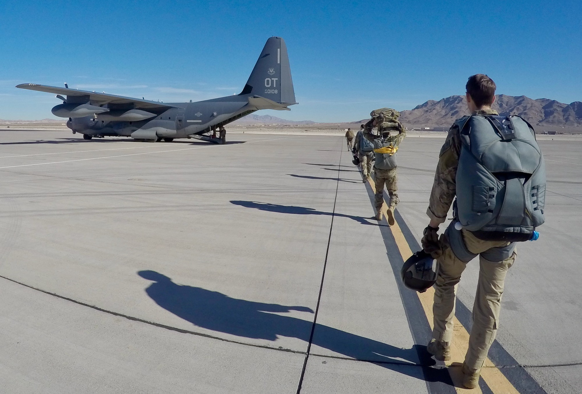 Photo of Airmen and HC-130J on flight line