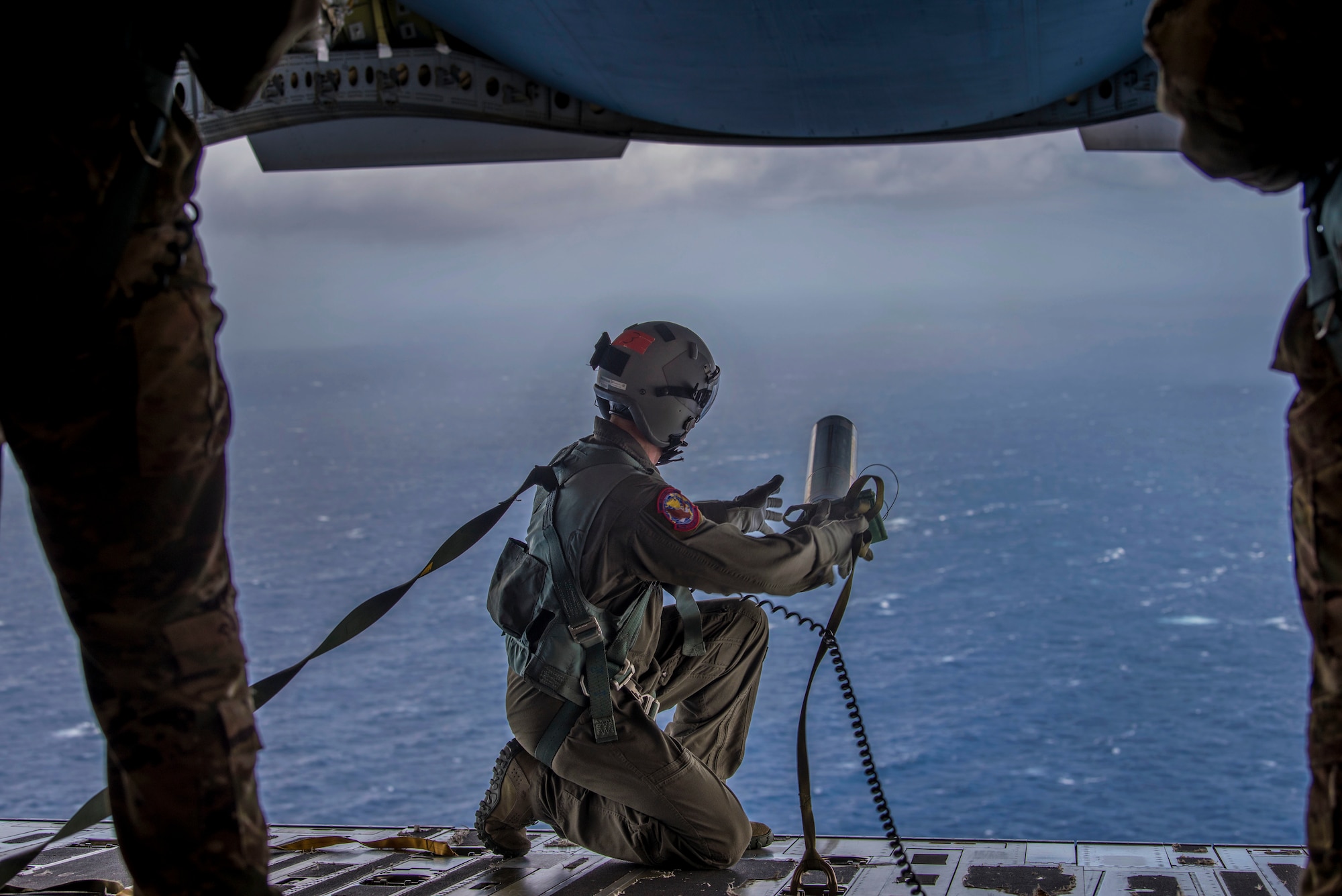 Tech. Sgt. Seth Dunworth, 15th Airlift Squadron loadmaster, deploys an illumination flare from the ramp of the aircraft during Air Mobility Command Test and Evaluation Squadron’s assessment of tactics, techniques and procedures for astronaut rescue and recovery efforts Jan. 22, 2020, off the coast of Florida near Patrick Air Force Base.  (U.S. Air Force photo by Staff Sgt. Tenley Long)