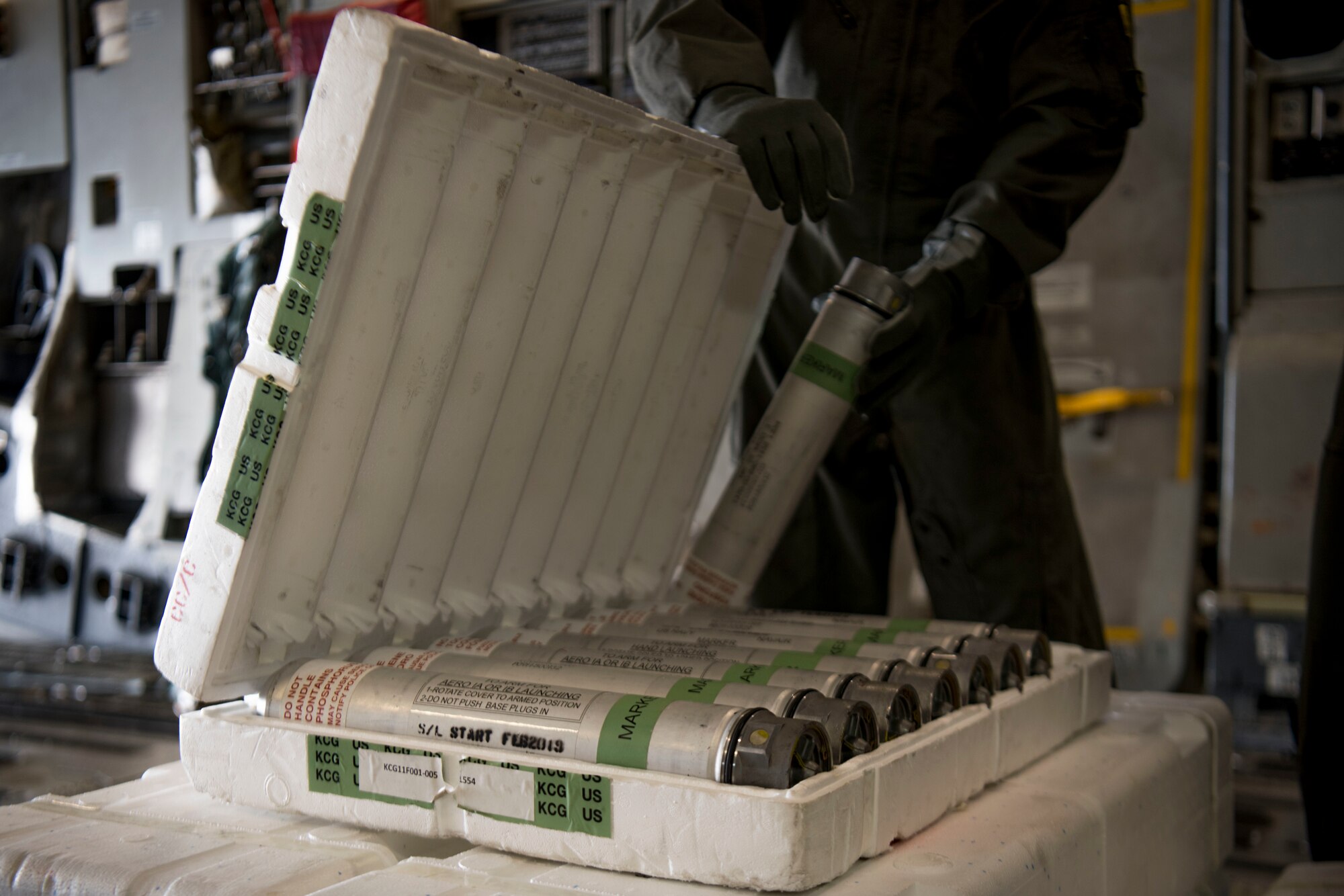 A loadmaster examines a crate of maritime position markers onboard a C-17 Globemaster III from Joint Base Charleston during Air Mobility Command Test and Evaluation Squadron’s assessment of tactics, techniques and procedures for astronaut rescue and recovery efforts Jan. 22, 2020, at Patrick Air Force Base, Fla.