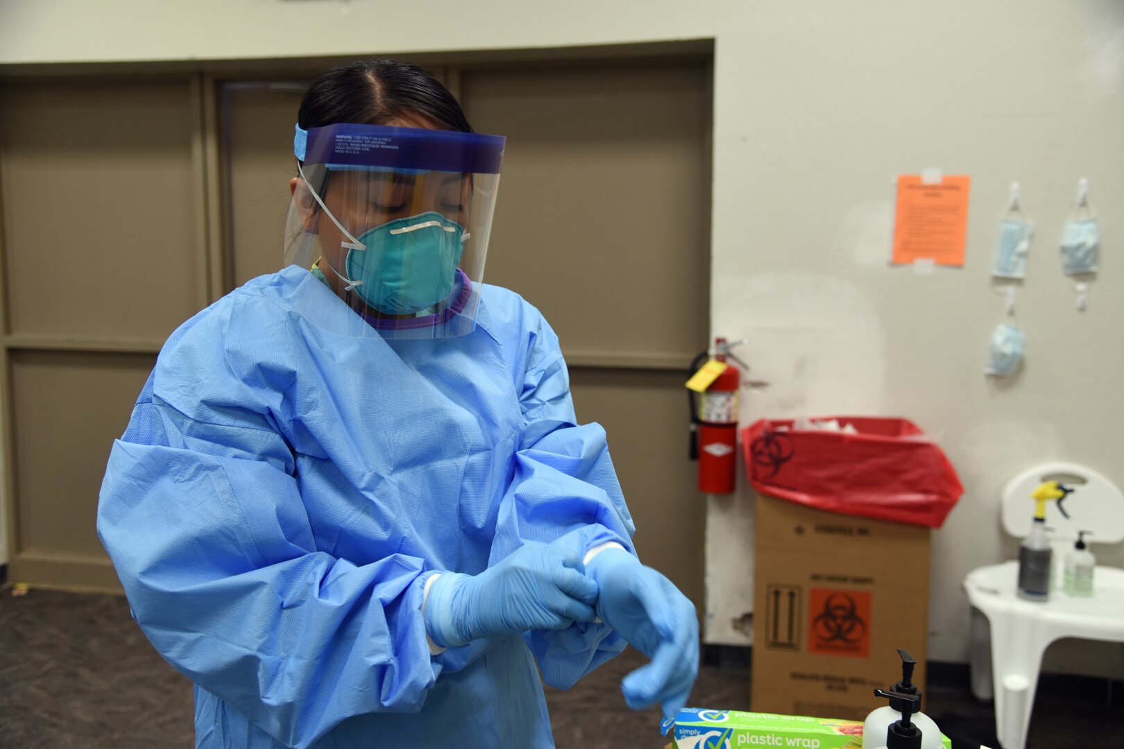 Spc. Paige Curtiss, 253rd Engineer Battalion, food service specialist, puts on personal protection equipment before entering a COVID-19 hot zone at an alternate care facility on the Navajo Nation in Chinle, Ariz., June 2, 2020.