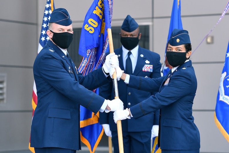 Col. Brian Kehl, 50th Mission Support Group commander, left, passes the 50th Force Support Squadron guidon to Maj. Gisselle Oppenlander, incoming 50th FSS commander, during a change of command ceremony June 30, 2020, at Schriever Air Force Base, Colorado. Oppenlander took command of the 50th FSS, which is responsible for providing installation personnel support activities to Schriever Airmen and civilian personnel. Oppenlander comes to Schriever from Hill AFB, Utah where she served as the deputy director of the 75th Force Support Squadron. (U.S. Air Force Photo by Dennis Rogers)