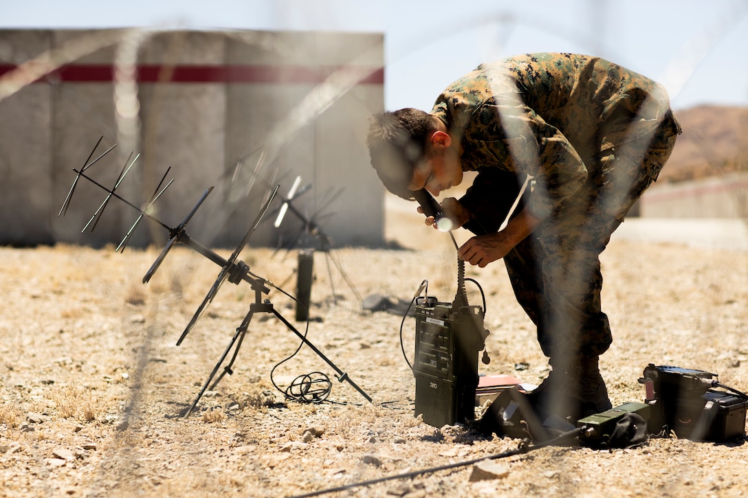 A U.S. Marine programs radios for communication across the training area for Raid 1 at Marine Corps Air Ground Combat Center Twentynine Palms, California, June 4.