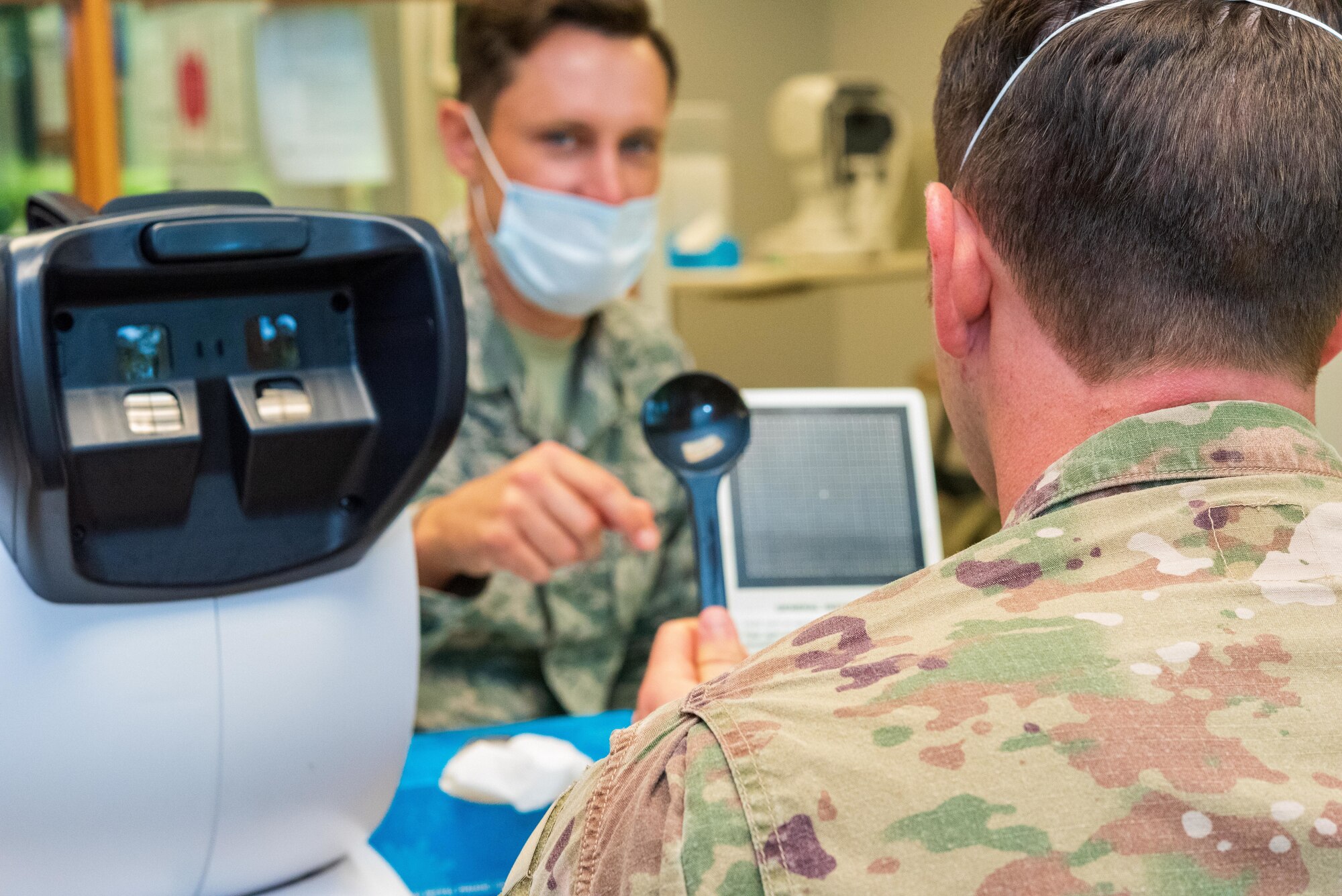 0003, 0010 - Air Force Reserve Senior Airman Lewis Alexander, 913th Aerospace Medicine Squadron optometry technician demonstrates an eye exam at Little Rock Air Force Base, Ark., June, 6, 2020. While adhering to COVID-19 health protection procedures, Alexander takes photos of the patient’s eye to assess vision and identify eye disorders, ensuring deployment readiness for Airmen and the group. Individual medical readiness includes a number of regular medical examinations required for deployment readiness. (U.S. Air Force Reserve photo by Maj. Ashley Walker)