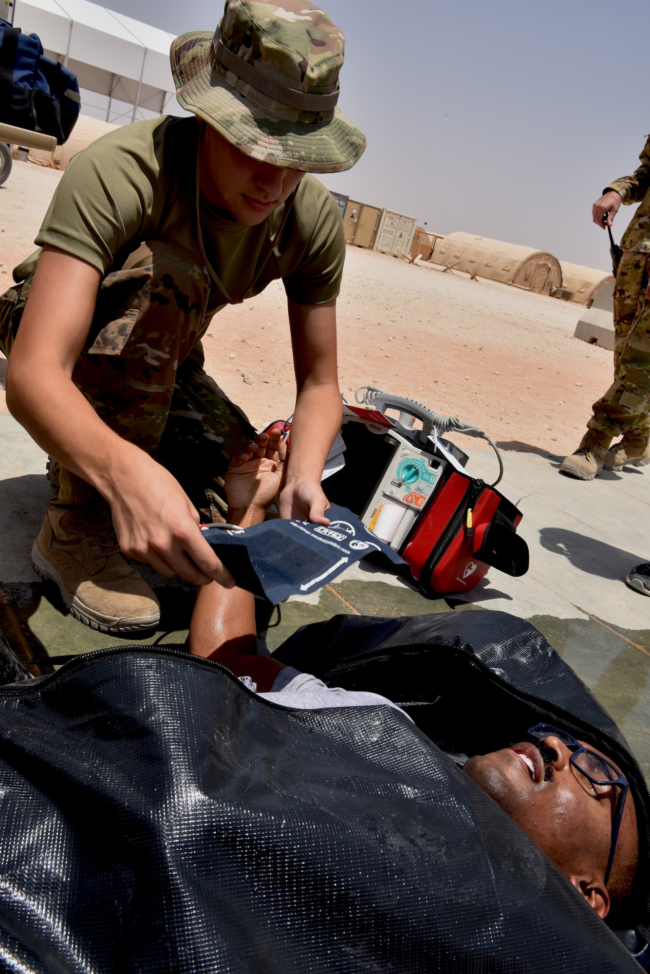 Medic Airmen from the 378th Expeditionary Medical Squadron train during a heat injury, rapid cool protocol exercise with firefighters from the 378th Expeditionary Civil Engineer Squadron at Prince Sultan Air Base, Kingdom of Saudi Arabia, July 1, 2020. Rapid response time to heat injuries is crucial for life-saving treatment for a patient. (U.S. Air Force photo by Master Sgt. Benjamin Wiseman)