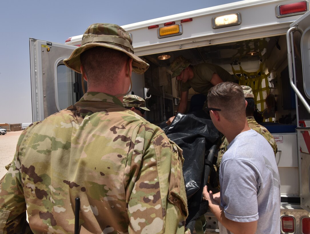 Medic Airmen from the 378th Expeditionary Medical Squadron train during a heat injury, rapid cool protocol exercise with firefighters from the 378th Expeditionary Civil Engineer Squadron at Prince Sultan Air Base, Kingdom of Saudi Arabia, July 1, 2020. Rapid response time to heat injuries is crucial for life-saving treatment for a patient. (U.S. Air Force photo by Master Sgt. Benjamin Wiseman)