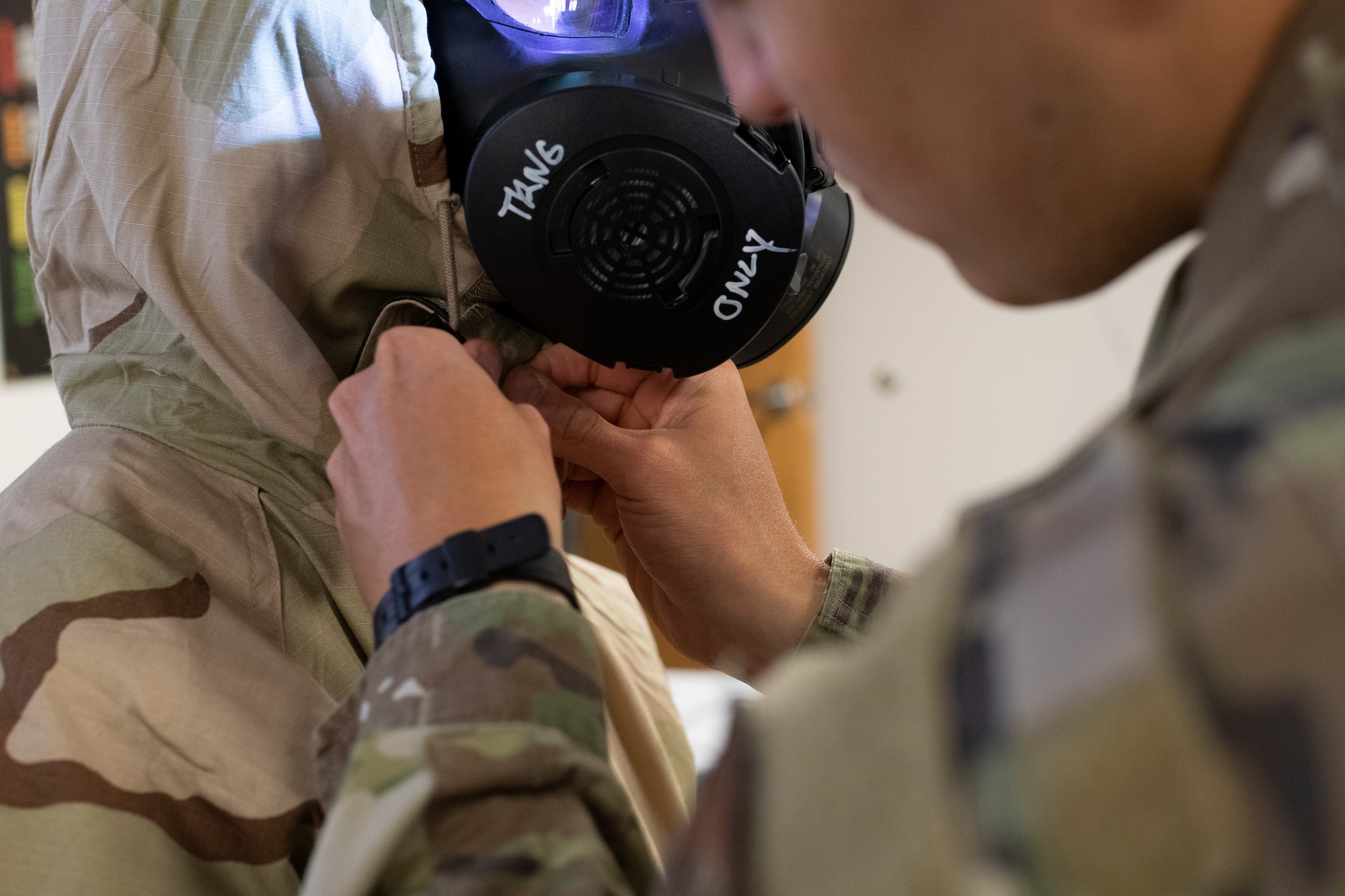 Photo of Airman donning chemical warfare gear.