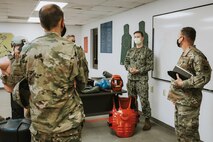 Master-at-Arms, Petty Officer Second Class Nick Zealy, a phoenix raven assigned to the 628th Security Forces Squadron, center, explains his mission set to Col. Marc Greene, 628th Air Base Wing commander, during an immersion brief at Joint Base Charleston, S.C.,  June 19, 2020.
