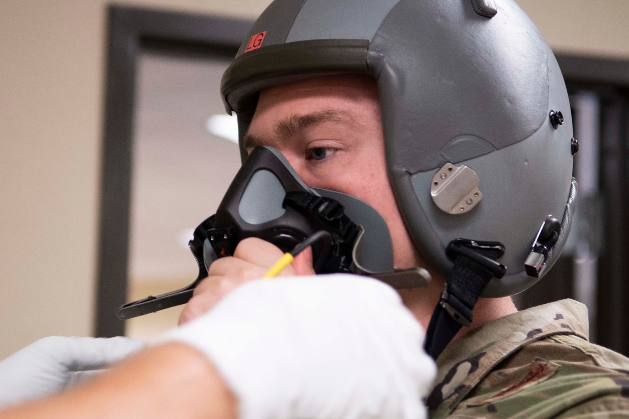 Photo of Airman being fit for helmet.