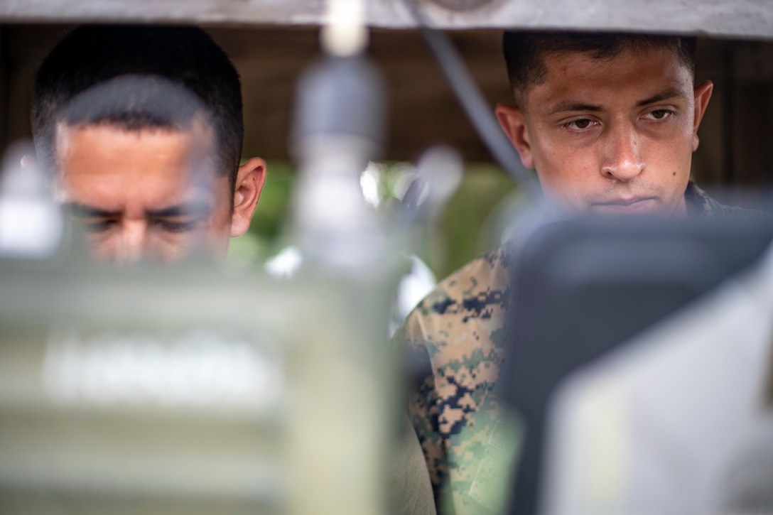 Sgt. Raul Sanchez, left, and Sgt. Vincent Rocha, right, both field radio operators with Special Purpose Marine Air-Ground Task Force - Southern Command, set up communication equipment during a field exercise at Camp Lejeune, North Carolina, June 9, 2020. The FEX provides the Marines and Sailors the opportunity to stay proficient with their equipment and refine their tactical skill sets. SPMAGTF-SC is poised to conduct crisis response, general engineering training and theater security cooperations alongside partner nation militaries in Latin America and the Caribbean. Sanchez is a native of Beaverton, Oregon. Rocha is from Kansas City, Missouri. (U.S. Marine Corps photo by Sgt. Andy O. Martinez)