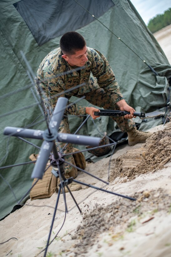 Sgt. Vincent Rocha, a field radio operator with Special Purpose Marine Air-Ground Task Force - Southern Command, sets up communication equipment during a field exercise at Camp Lejeune, North Carolina, June 11, 2020. The FEX provides the Marines and Sailors the opportunity to stay proficient with their equipment and refine their tactical skill sets. SPMAGTF-SC is poised to conduct crisis response, general engineering training and theater security cooperations alongside partner nation militaries in Latin America and the Caribbean. Rocha is from Kansas City, Missouri. (U.S. Marine Corps photo by Sgt. Andy O. Martinez)