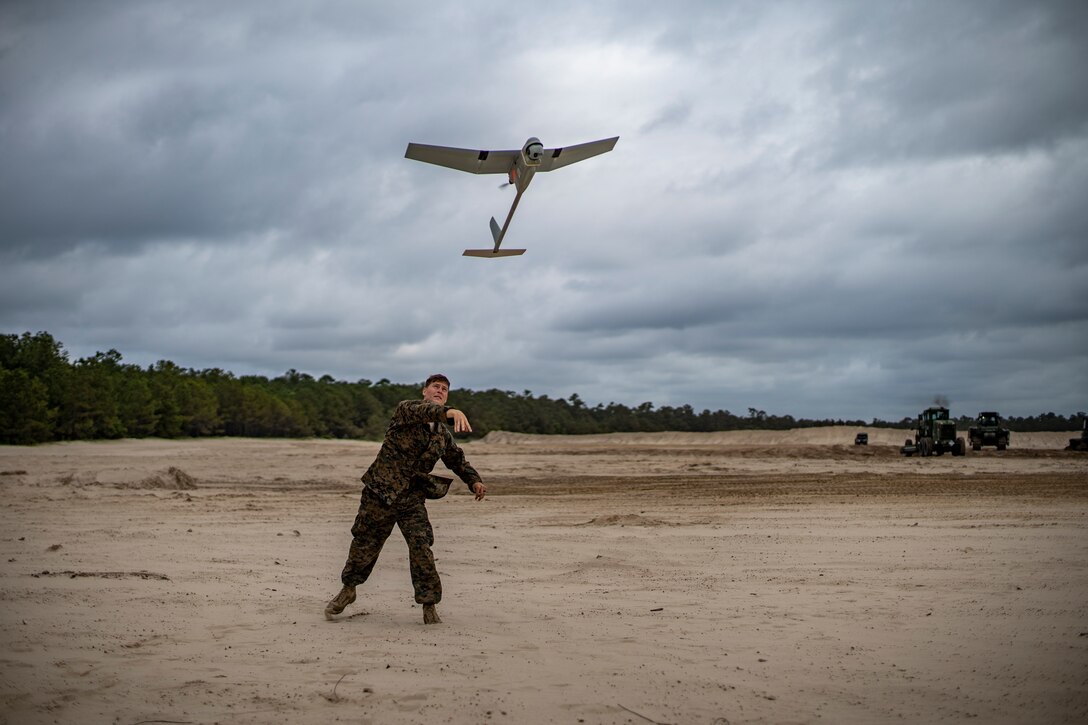 Cpl. Nicholas Whisenhunt, an engineer equipment operator with Special Purpose Marine Air-Ground Task Force - Southern Command, launches an RQ-11B Raven during a field exercise at Camp Lejeune, North Carolina, June 11, 2020. The FEX provides the Marines and Sailors the opportunity to stay proficient with their equipment and refine their tactical skill sets. SPMAGTF-SC is poised to conduct crisis response, general engineering training and theater security cooperations alongside partner nation militaries in Latin America and the Caribbean. Whisenhunt is a native of Keizer, Oregon. (U.S. Marine Corps photo by Sgt. Andy O. Martinez)