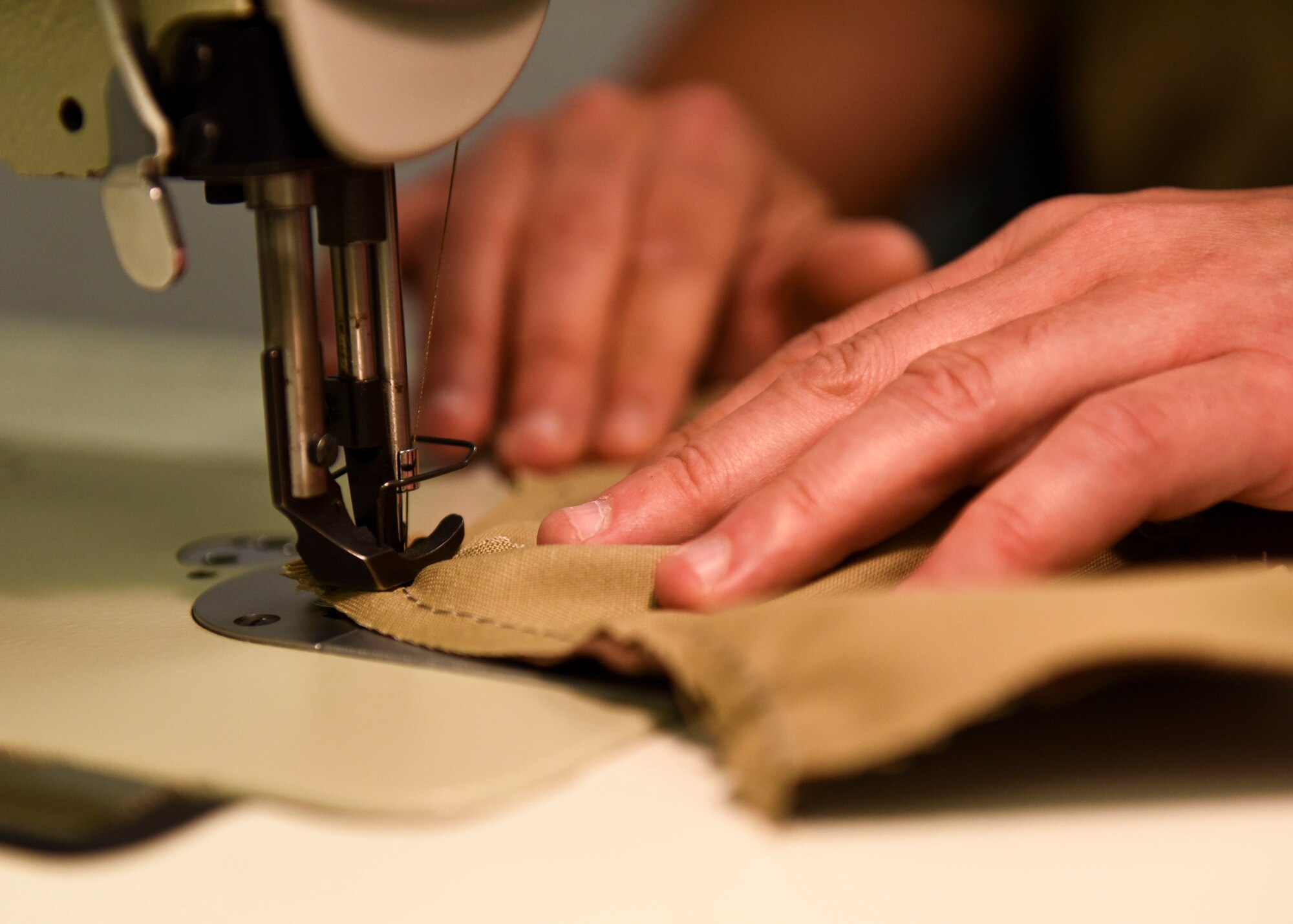An Aircrew Flight Equipment technician sews a mask. Guardsmen are to wear masks at all times except when isolted from others and in a private place. (U.S. Air National Guard photo by Senior Airman Zoe M. Wockenfuss)