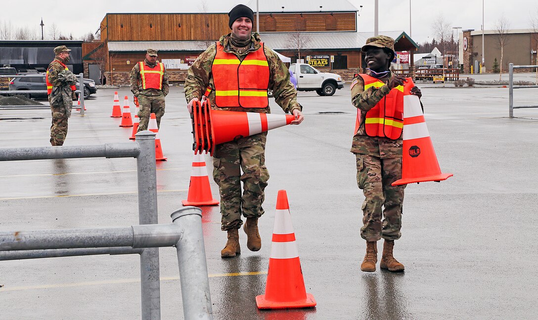 Alaska National Guard Soldiers assigned to Joint Task Force Alaska place construction cones around the perimeter of an expedient, Food Bank of Alaska distrobution center in Anchorage, Alaska, Apr. 20, 2020. Amidst the COVID-19 pandemic, AKNG Soldiers worked in a joint, logistical effort to assist the local food banks in feeding local Alaskans in need. (U.S. Army National Guard photo Sgt. Seth LaCount/Released)