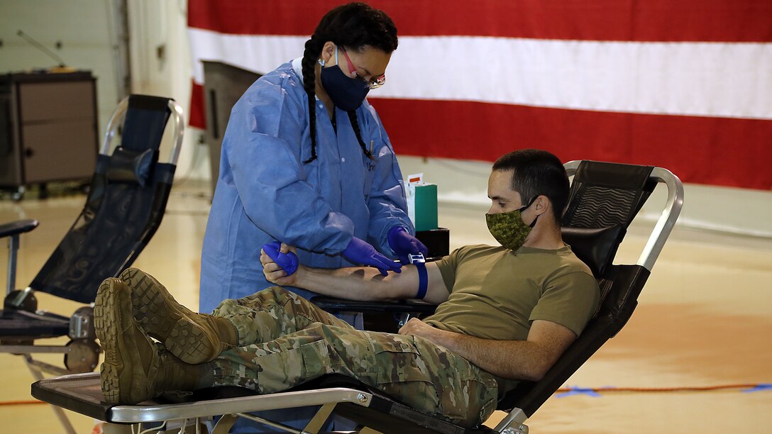 Alaska Army National Guard Capt. James Tollefson, an operations plans officer with Joint Task Force-Alaska, donates blood at the Guard Armory on Joint Base Elmendorf-Richardson, May 26, 2020. Blood donation centers have been impacted by a lack of donors during the COVID-19 pandemic, while the need for blood, plasma and platelets continue to be critically needed for many medical services. (U.S. Army National Guard photo by Sgt. Seth LaCount/Released)