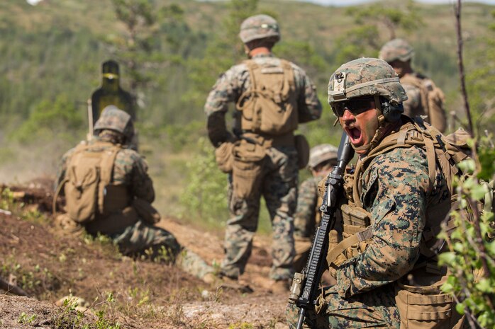 A U.S. Marine shouts orders to surrounding squad members during a squad fire and movement range at the Haltdalen Training Facility, Norway, June 21.