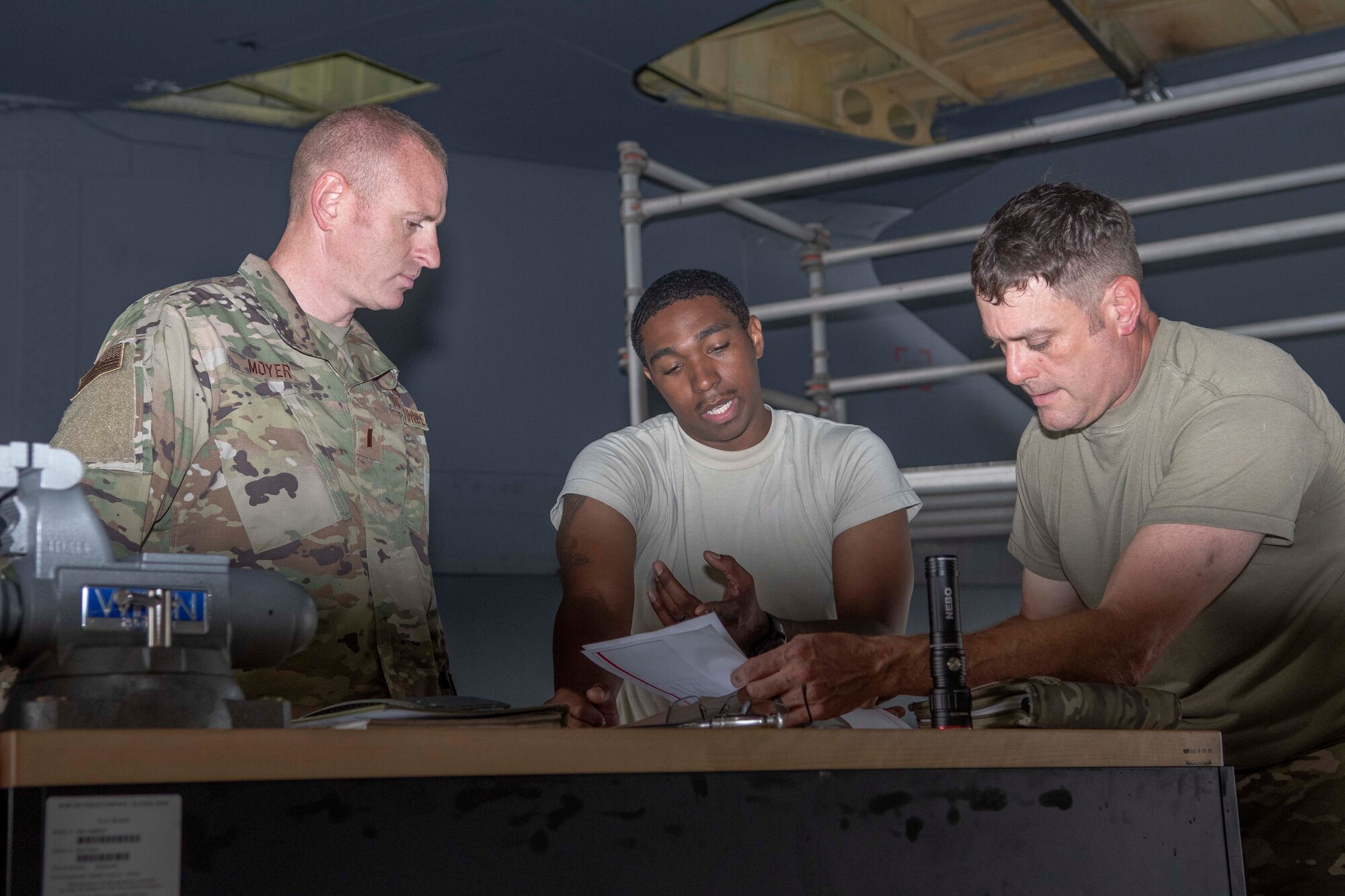 Photo of Airmen speaking around a table.