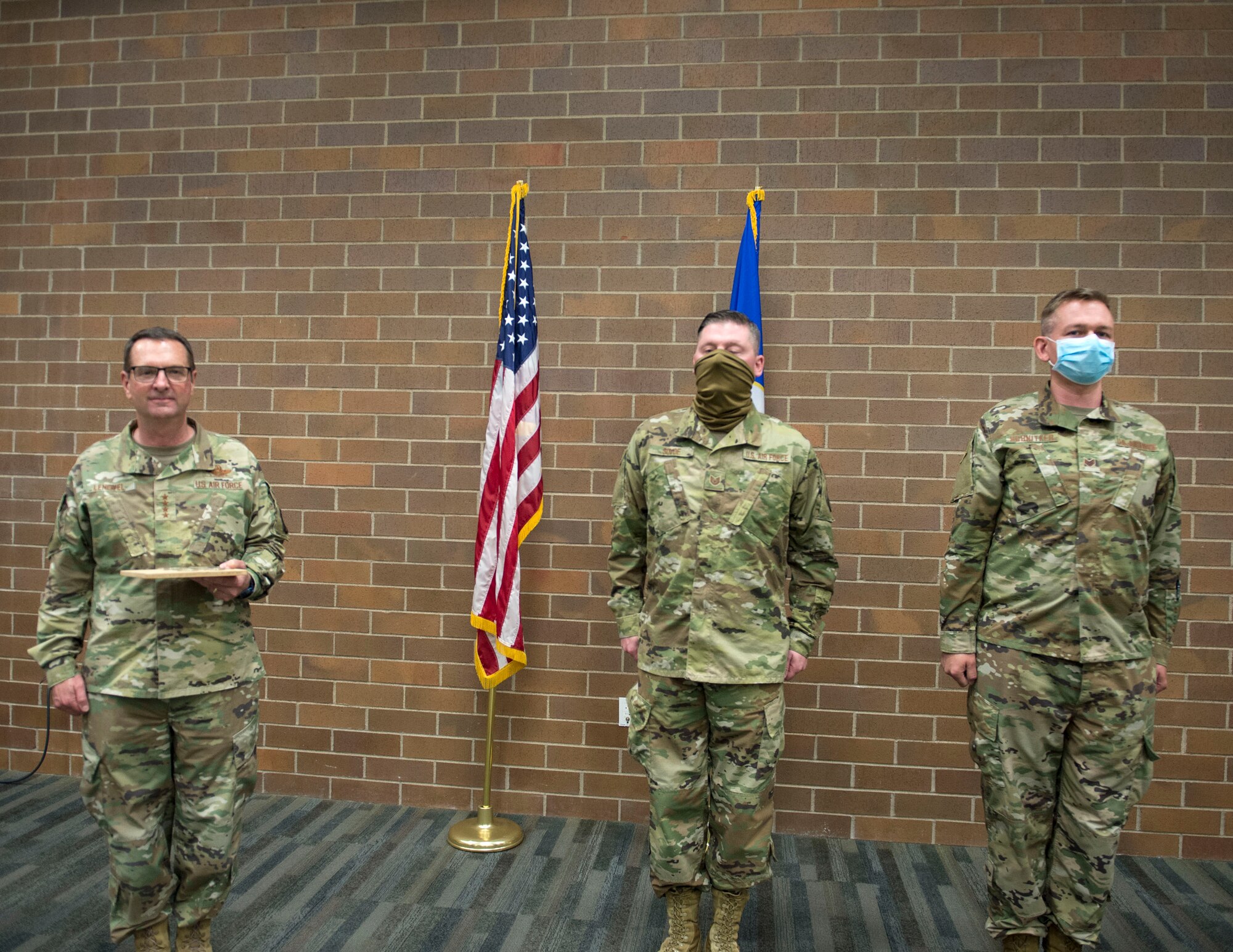 U.S. Air Force Tech. Sgt. Kyle Sovde, center, and Staff Sgt. Tyson Schnitker from the 133rd Medical Group were recognized by U.S. Air Force Gen. Joseph L. Lengyel, Chief of the National Guard Bureau, for their work during the COVID-19 and civil unrest State Active Duty assignments in St. Paul, Minn., June 17, 2020.