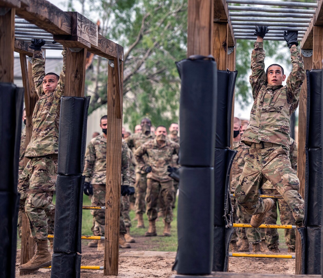 Nicolas (left) and his brother Daniel (right) Hughes, U.S. Air Force basic training trainee, run through an obstacle course May 21 at Joint Base San Antonio-Chapman Annex.