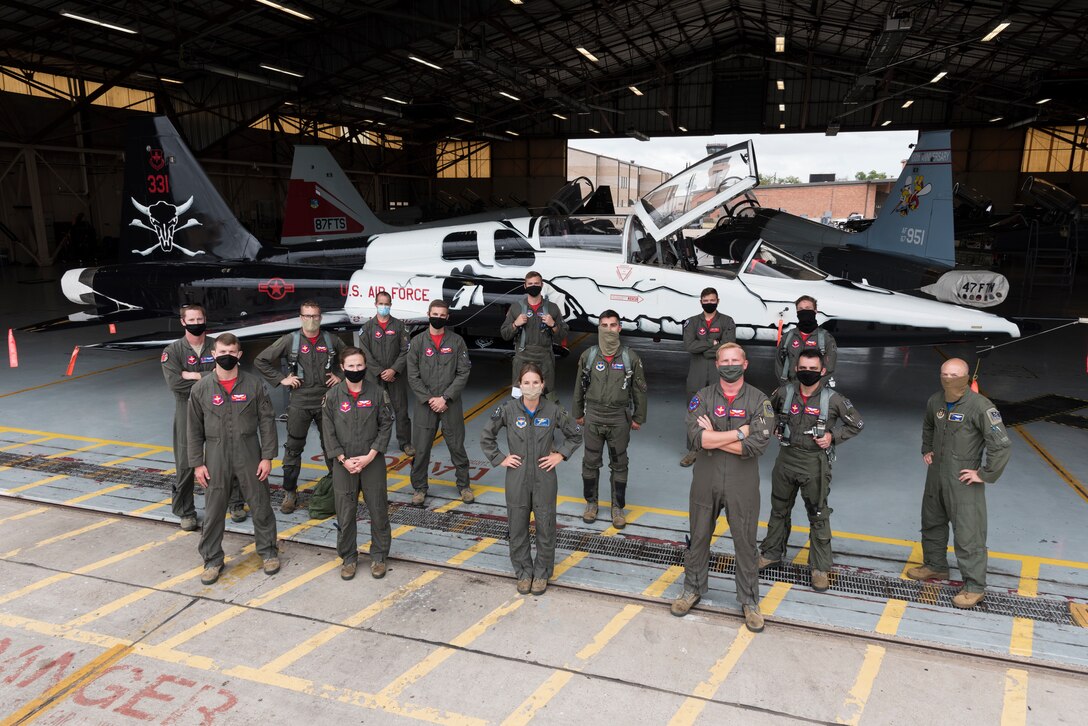 First assignment instructor pilots from the 87th Flying Training Squadron stand together at their flagship’s reveal June 26, 2020 at Laughlin Air Force Base, Texas. “We bring a different set of experiences and instruction as first assignment instructor pilots when compared with our counterparts on the operational side,” Capt. Melaine Valentin, 47th Student Squadron instructor pilot and art designer for the first assignment instructor pilot flagship, said. “It’s not always easy watching your undergraduate pilot training classmates go and travel the world, moving cargo, executing airstrikes, and deploying while you remain at Laughlin instructing. However, it’s an important mission we accomplish here at Laughlin, and so are the friendships and experiences we build here. The FAIP jet represents that.” (U.S. Air Force Photo by Senior Airman Anne McCready)