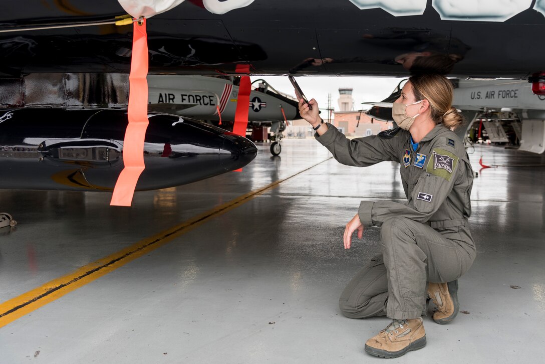 Capt. Melaine Valentin, 47th Student Squadron instructor pilot and art designer for the first assignment instructor pilot flagship, takes pictures of the aircraft after its reveal June 26, 2020 at Laughlin Air Force Base, Texas. Valentin described how incredible it was to see everyone’s hard work come to fruition. “Getting to see the glossy paint up-close and personal is always awesome; as much as these jets fly, it won’t stay clean and shiny forever,” she said. (U.S. Air Force Photo by Senior Airman Anne McCready)