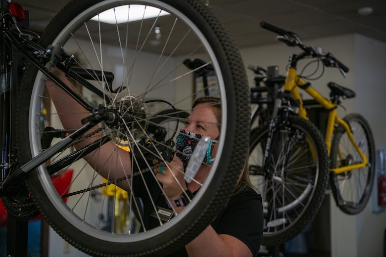 Andi Hickman, Outdoor Recreation associate, adjusts mountain bike brakes June 16, 2020, at Luke Air Force Base, Ariz.