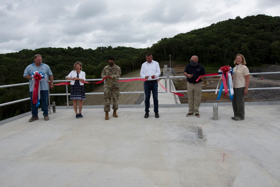 (Left to Right) Bill DeBruyn, U.S. Army Corps of Engineers Nashville District construction liaison; Tennessee District 40 Rep. Terri Lynn Weaver; Lt. Col. Sonny Avichal, Nashville District commander; Steve Kohler, president and chief executive officer of Thalle Construction Corporation; David W. Salyers, P.E., Commissioner of Tennessee Department of Environment and Conservation; and Linda Adcock, Corps of Engineers retiree and former project manager; cut a ribbon signifying the completion of the roller compacted concrete berm and the overarching Center Hill Dam Safety Rehabilitation Project. (USACE Photo by Lee Roberts)