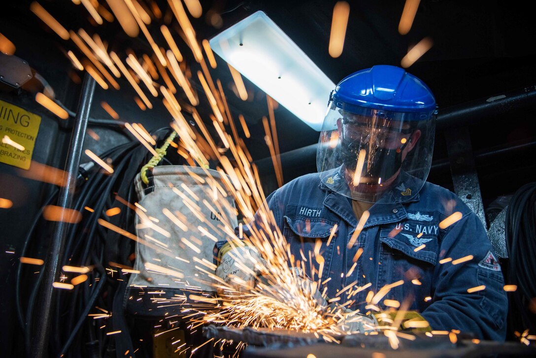 Sparks fly while a welder works on metal.