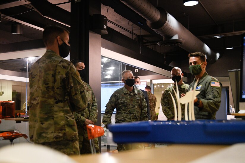 Maj. Vincent Giacomino (right) briefs Col. Tyler R. Schaff (center), 316th Wing and Joint Base Andrews commander, and Col. Stephen P. Snelson (left), 89th Airlift Wing commander, on the SparkX Cell program and its mission during an immersion tour at the SparkX Cell Innovation and Idea Center, Joint Base Andrews, Md., on June 29, 2020.