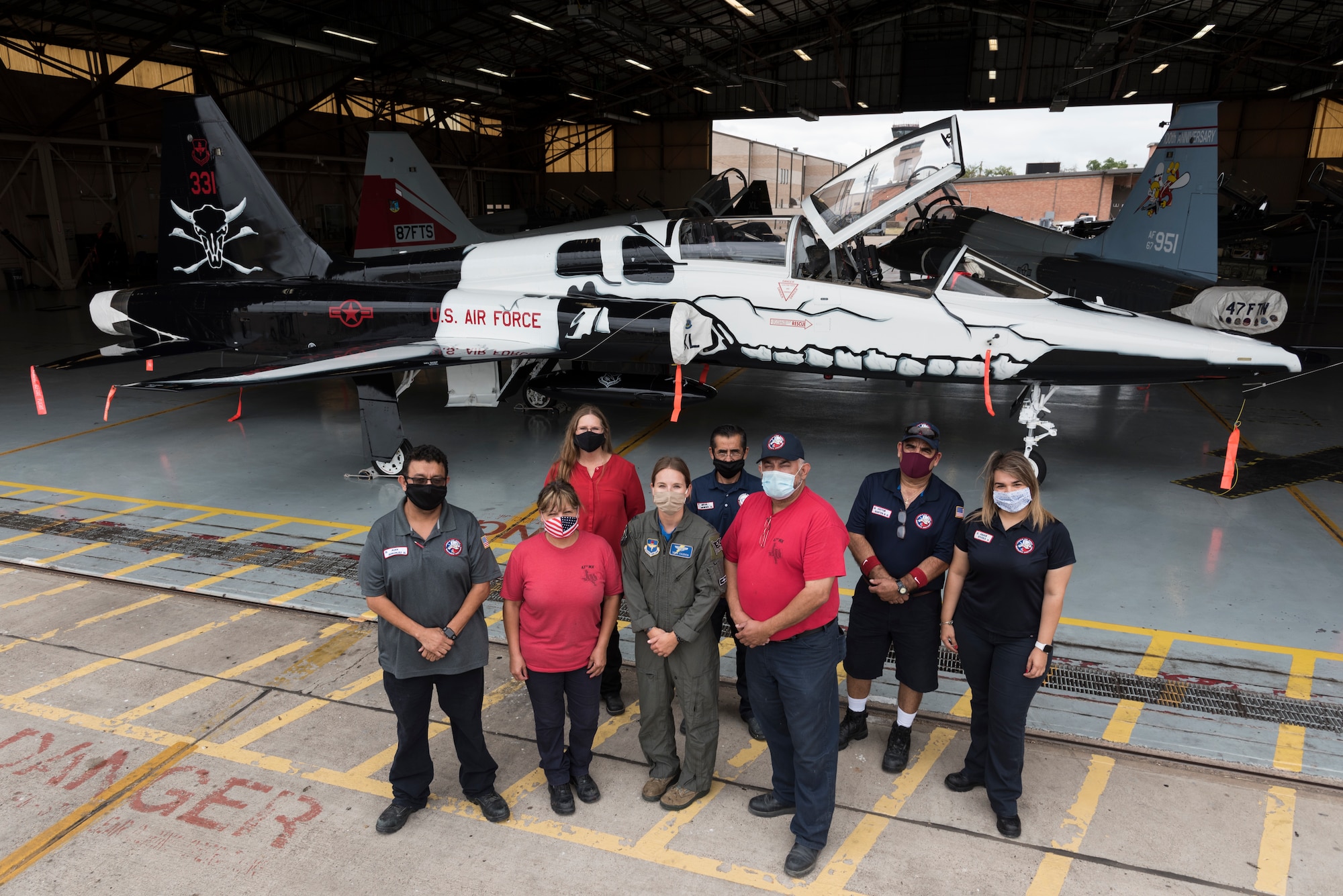 The 47th Maintenance Directorate corrosion control team who painted Laughlin’s aircraft, and Capt. Melaine Valentin, 47th Student Squadron instructor pilot and art designer for the first assignment instructor pilot flagship, gather for a photo at the unveiling of the T-38C Talon FAIP flagship July 26, 2020 at Laughlin Air Force Base, Texas. Valentin provided the 47th MXD’s corrosion control team with a 2D plan for the aircraft's paint design, and the corrosion control team turned it into a 3D reality. (U.S. Air Force Photo by Senior Airman Anne McCready)