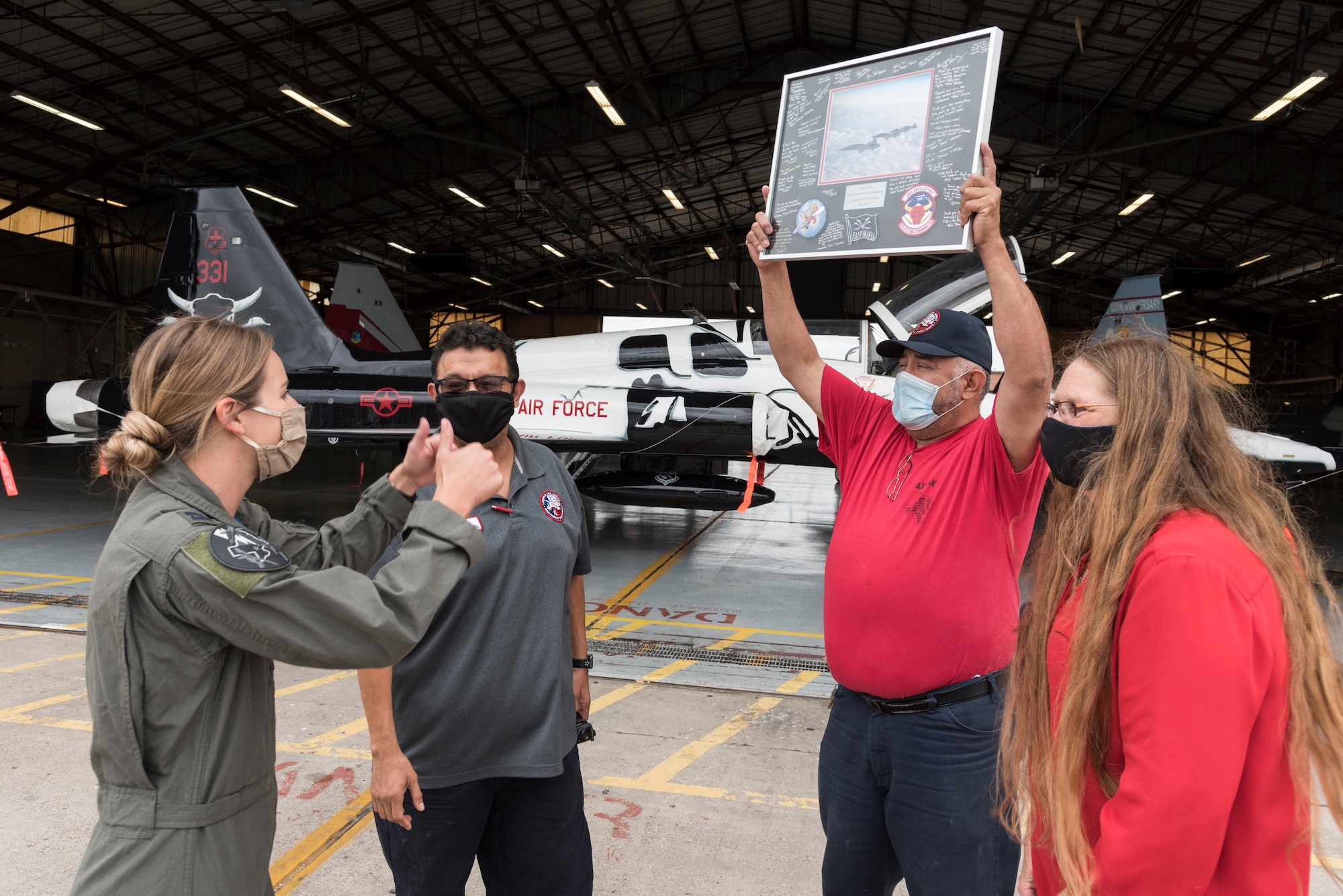 The 47th Maintenance Directorate corrosion control team who paint Laughlin’s aircraft, celebrate after Capt. Melaine Valentin, 47th Student Squadron instructor pilot, presents the team with a thank you gift from the 87th FTS at the unveiling of the T-38C Talon FAIP flagship July 26, 2020 at Laughlin Air Force Base, Texas. Valentine believes having their own flagship will inspire FAIPS to keep holding the line, pursue the mission, and wave the FAIP flap with pride for years to come. (U.S. Air Force Photo by Senior Airman Anne McCready)