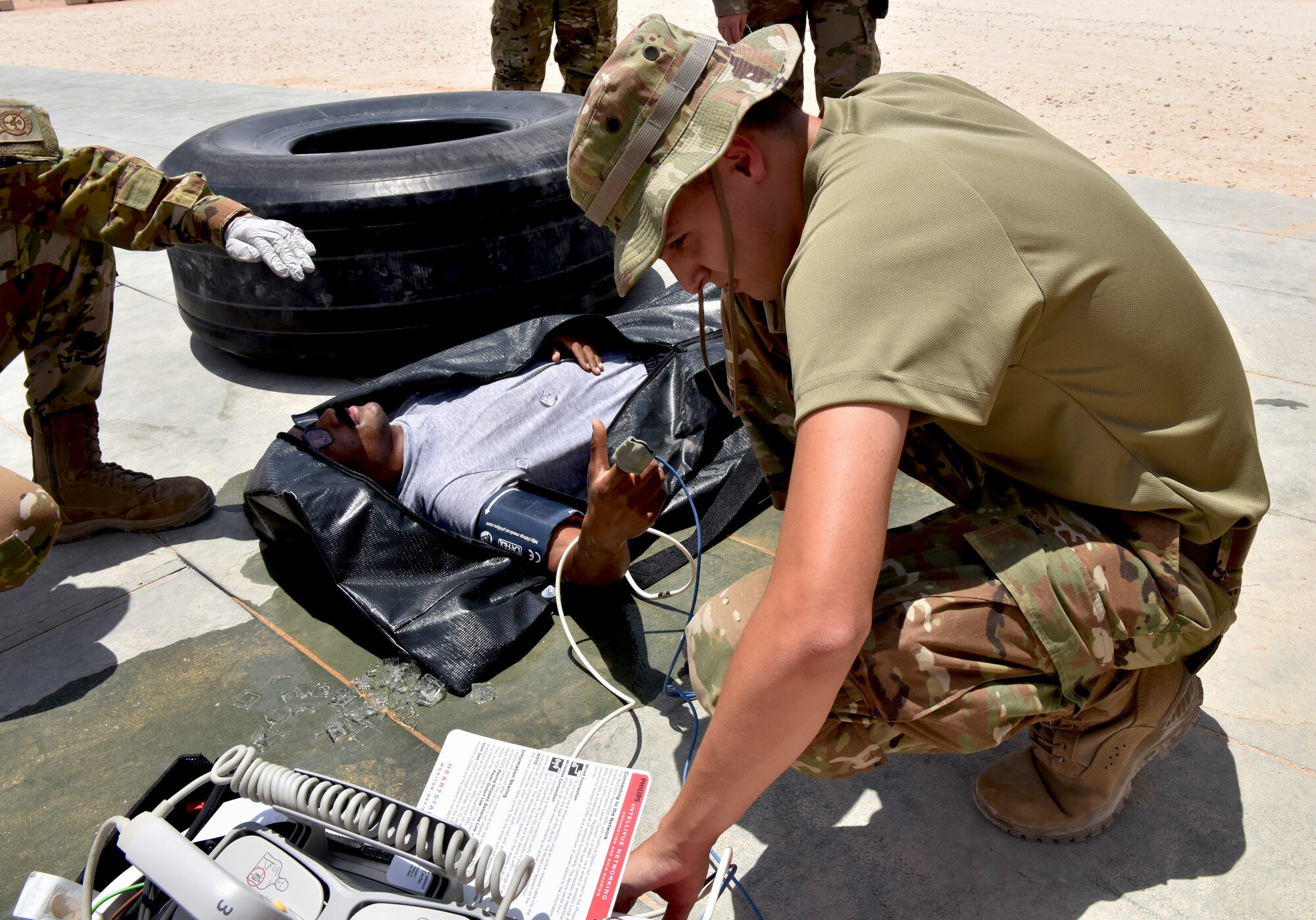 Medic Airmen from the 378th Expeditionary Medical Squadron train during a heat injury, rapid cool protocol exercise with firefighters from the 378th Expeditionary Civil Engineer Squadron at Prince Sultan Air Base, Kingdom of Saudi Arabia, July 1, 2020. Rapid response time to heat injuries is crucial for life-saving treatment for a patient. (U.S. Air Force photo by Master Sgt. Benjamin Wiseman)