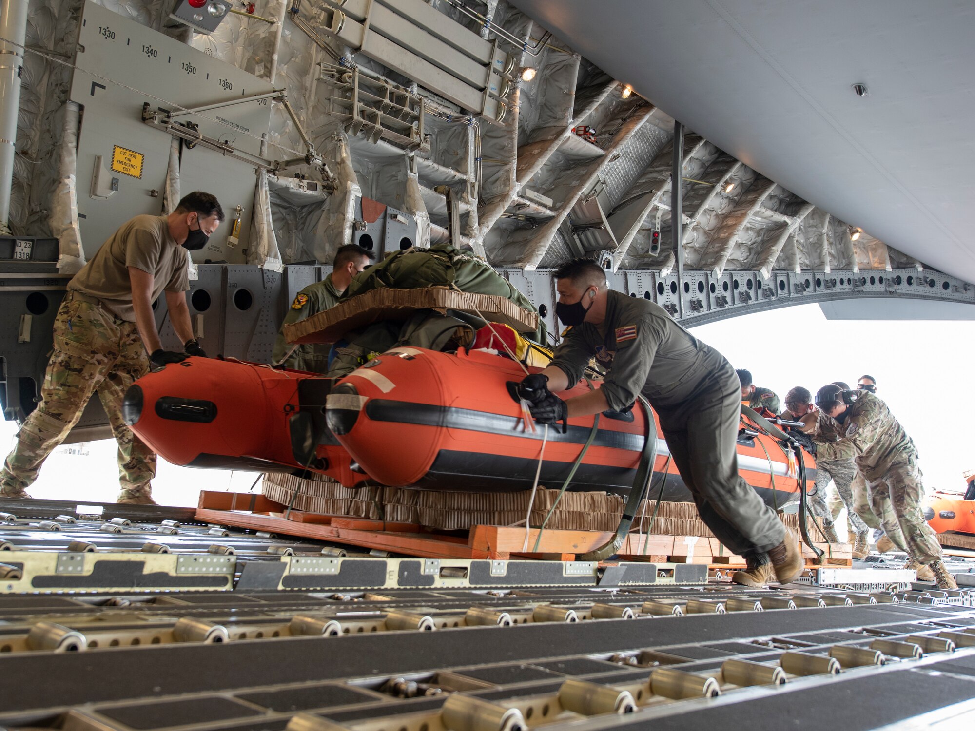 U.S. Air Force Airmen, assigned to the Hawaii Air National Guard, load pararescuemen equipment onto a C-17 Globemaster III, May 26, 2020 at Joint Base Pearl Harbor-Hickam. The Airmen pre-rigged the C-17 in order to be able to quickly respond to astronaut rescue in the Pacific region in support of a manned space flight launch on May 30. (U.S. Air National Guard photo by Senior Airman Orlando Corpuz)