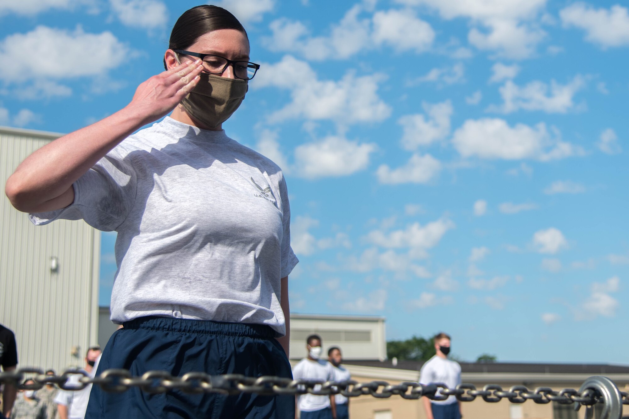 Airman 1st Class Lauren Orton, a 436th Aerial Port Squadron inbound cargo specialist, salutes a photo of a fallen wingman during a ceremony prior to the annual Port Dawg Memorial 5K June 29, 2020, at Dover Air Base, Delaware. This year, there was a total of 11 tie-downs representing fallen Port Dawgs. (U.S. Air Force photo by Airman 1st Class Faith Schaefer)