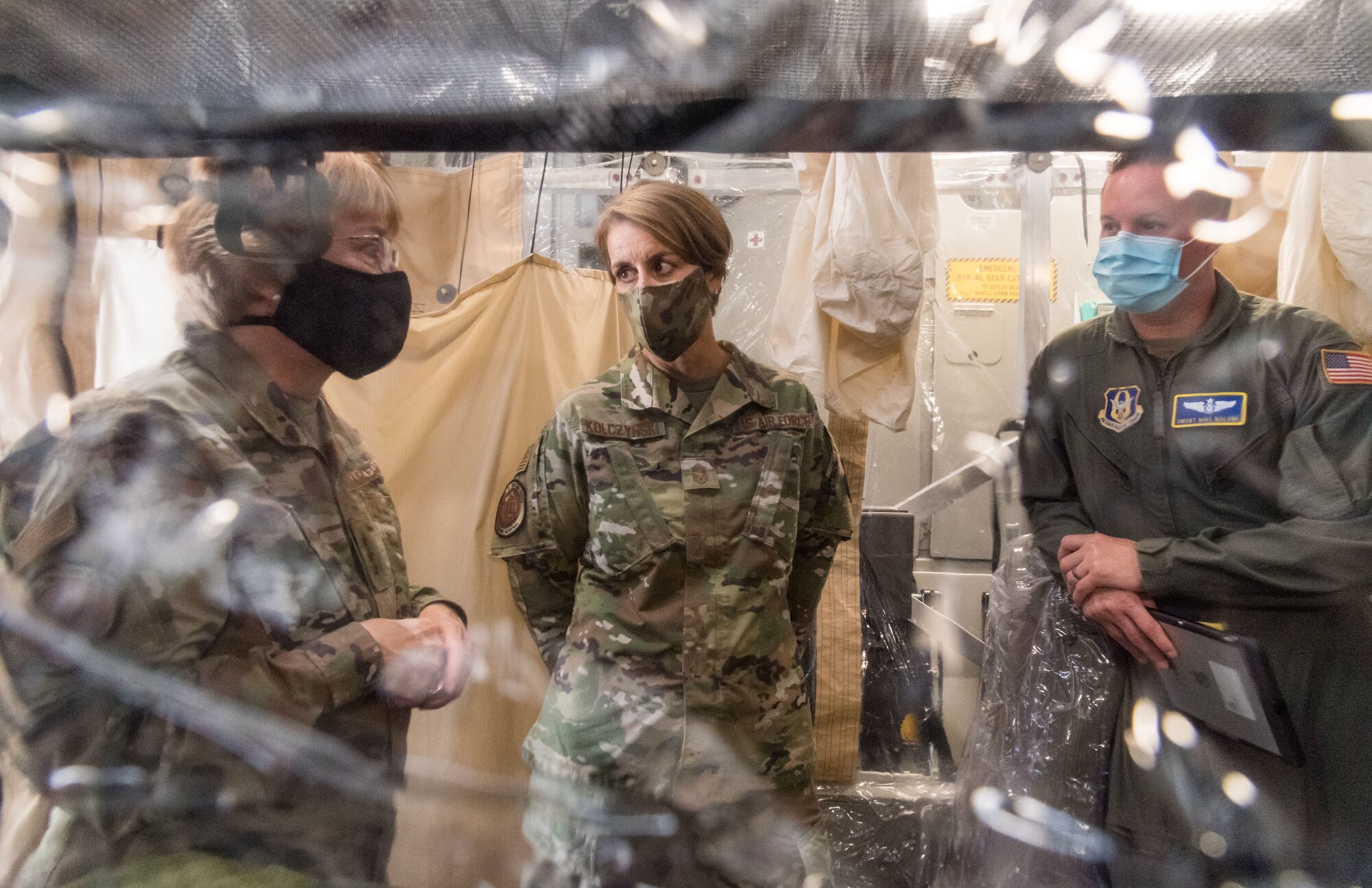 From the left, Lt. Gen. Dorothy Hogg, U.S. Air Force surgeon general, and Chief Master Sgt. Dawn Kolczynski, AF/SG chief of medical operations, talk with Senior Master Sgt. Michael Malone, 36th Aeromedical Evacuation Squadron training noncommissioned officer in charge and AE technician, from Keesler Air Force Base, Mississippi, inside a Transport Isolation System, June 26, 2020, at Dover Air Force Base, Delaware. Dover serves as the U.S. East Coast hub for the TIS. (U.S. Air Force photo by Roland Balik)