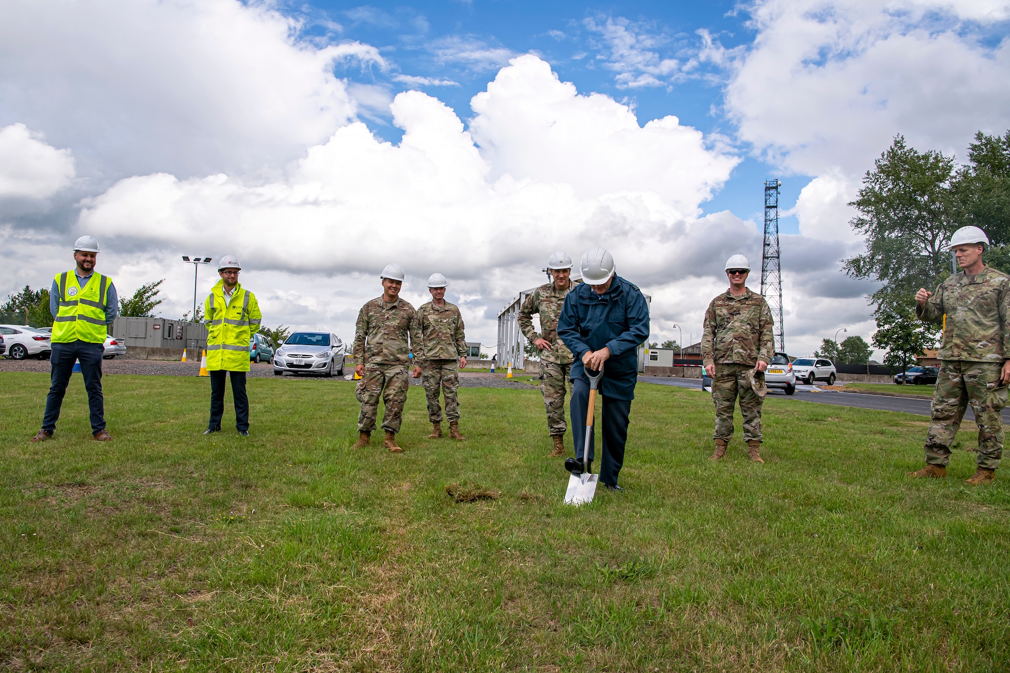 Royal Air Force (RAF) Squadron Leader Clive Wood (center), RAF Alconbury and RAF Molesworth commander, breaks ground on a construction project for the main gate at RAF Alconbury, England, July 2, 2020. Construction will commence on July 6, 2020 and effective from that date, installation entry and exit procedures will be modified to support the construction project. This project will provide a large vehicle inspection station, channelized traffic flow for better security and improved safety for personnel. (U.S. Air Force photo by Senior Airman Eugene Oliver)