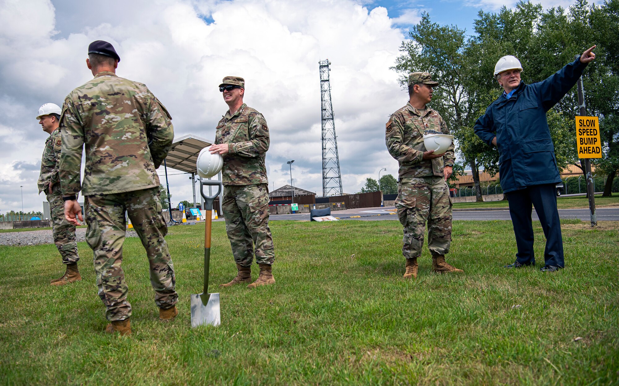 Royal Air Force Squadron Leader Clive Wood (right), RAF Alconbury and RAF Molesworth commander, speaks with U.S. Air Force Maj. Chin Hsu (center right), 423d Civil Engineer Squadron commander, about a construction project for the main gate at RAF Alconbury, England, July 2, 2020. Construction will commence on July 6, 2020 and effective from that date, installation entry and exit procedures will be modified to support the construction project. This project will provide a large vehicle inspection station, channelized traffic flow for better security and improved safety for personnel. (U.S. Air Force photo by Senior Airman Eugene Oliver)